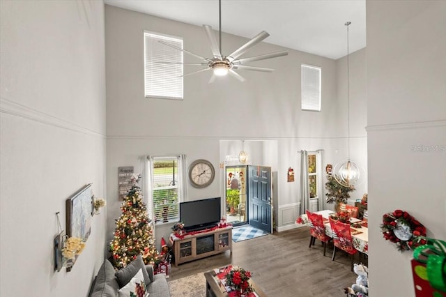 living room featuring ceiling fan, a high ceiling, and hardwood / wood-style flooring