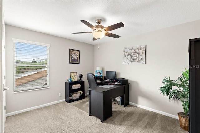 office space featuring a textured ceiling, light colored carpet, and ceiling fan