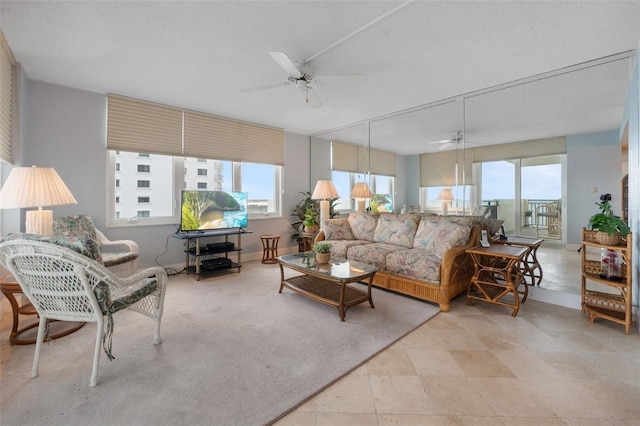 living room with ceiling fan and a textured ceiling