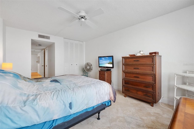 bedroom with ceiling fan, a closet, and a textured ceiling