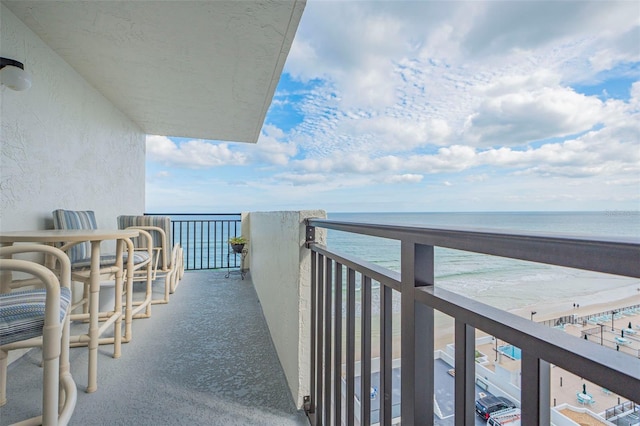 balcony with a water view and a beach view