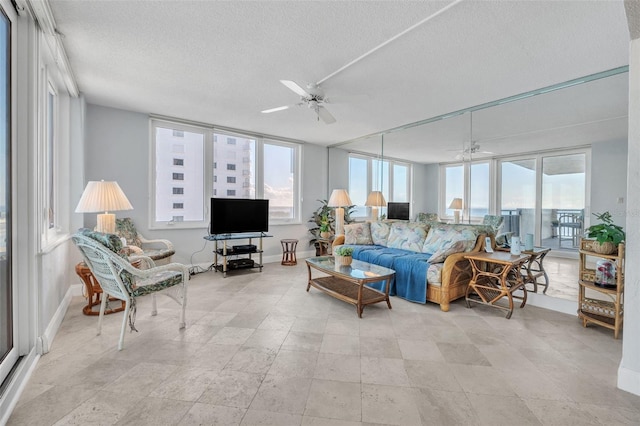 living room featuring ceiling fan and a textured ceiling