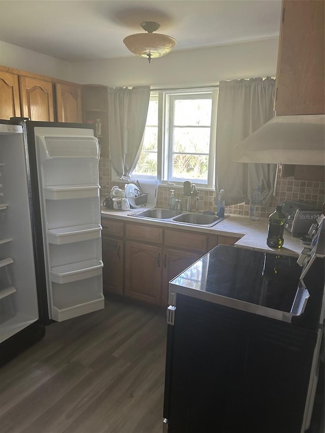 kitchen with sink, backsplash, dark wood-type flooring, and range with electric cooktop