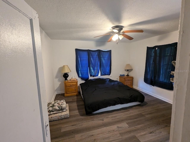 bedroom with dark hardwood / wood-style floors, a textured ceiling, and ceiling fan