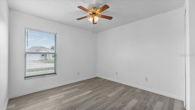 empty room featuring light wood-type flooring, a textured ceiling, and ceiling fan