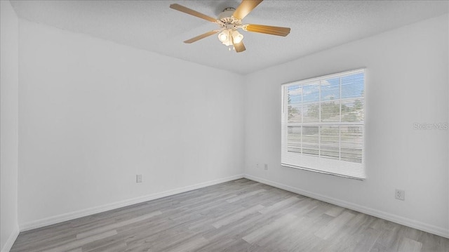 empty room featuring ceiling fan, a textured ceiling, and light hardwood / wood-style flooring