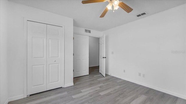 unfurnished bedroom featuring ceiling fan, light wood-type flooring, and a closet