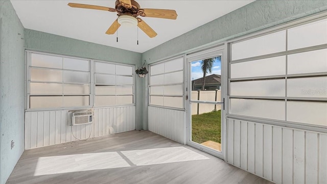 interior space featuring a wall mounted air conditioner and ceiling fan