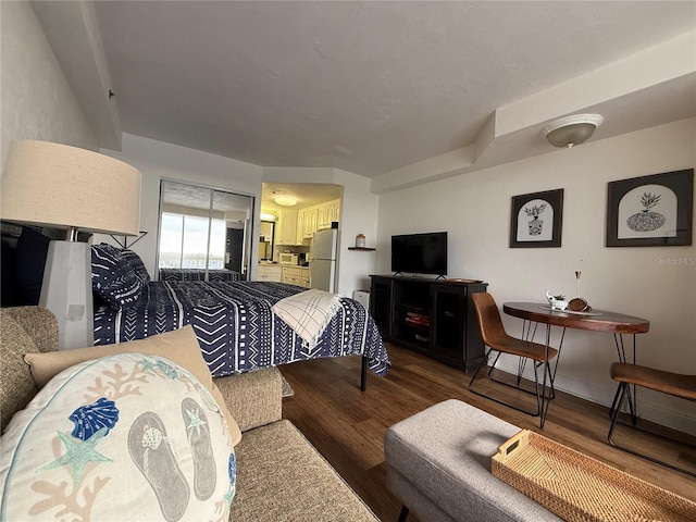 bedroom with wood-type flooring and white refrigerator