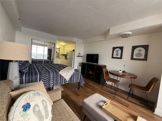 bedroom featuring hardwood / wood-style floors and white fridge