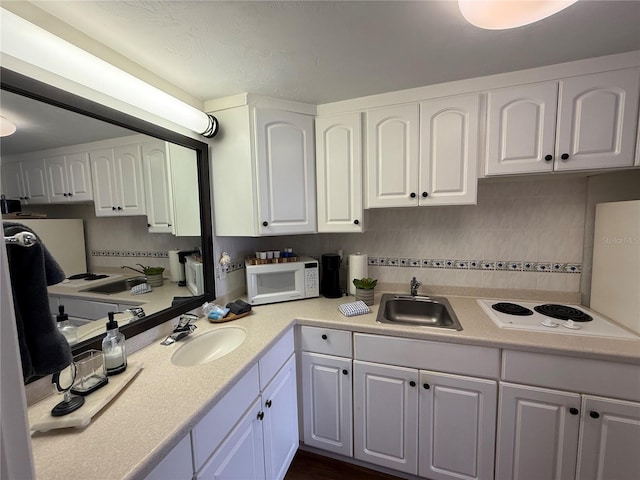 kitchen featuring white cabinets, white appliances, and sink