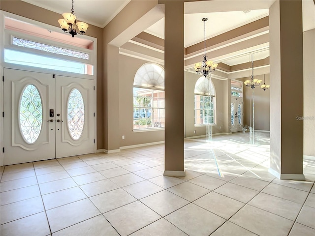 tiled foyer featuring french doors, a chandelier, and ornamental molding