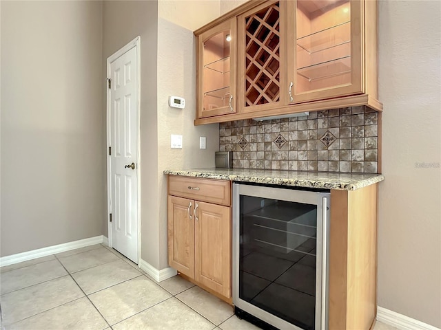 bar featuring tasteful backsplash, wine cooler, light stone countertops, and light tile patterned floors