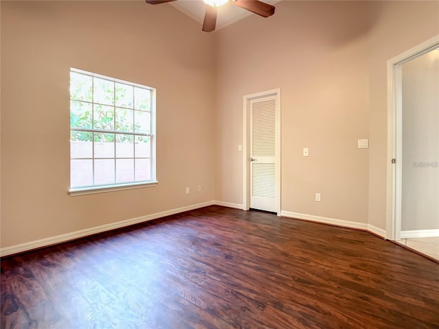 spare room featuring beamed ceiling, high vaulted ceiling, ceiling fan, and dark wood-type flooring