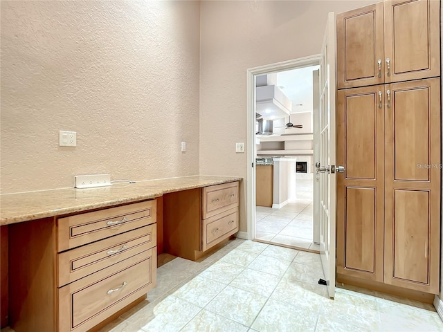 office space with built in desk and light tile patterned floors