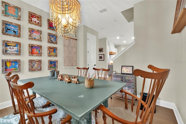 dining space featuring hardwood / wood-style floors and a chandelier