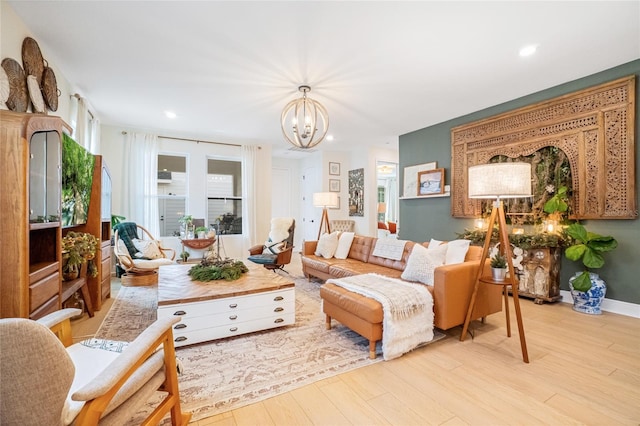 living room featuring light wood-type flooring, a wealth of natural light, and a chandelier