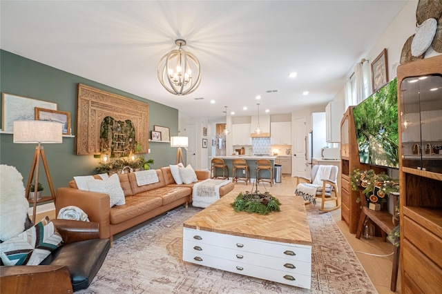 living room with light wood-type flooring and a notable chandelier