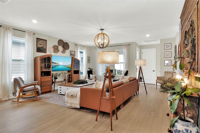 living room featuring an inviting chandelier and light hardwood / wood-style flooring