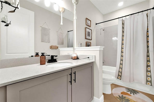 full bathroom featuring hardwood / wood-style floors, vanity, shower / tub combo with curtain, and toilet