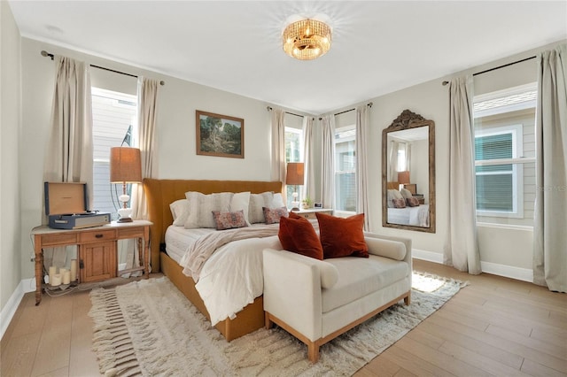 bedroom featuring multiple windows and light hardwood / wood-style floors