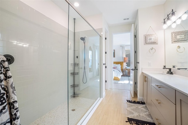 bathroom featuring vanity, wood-type flooring, and tiled shower