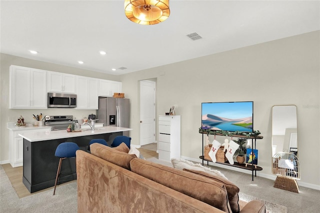 living room with light colored carpet and sink