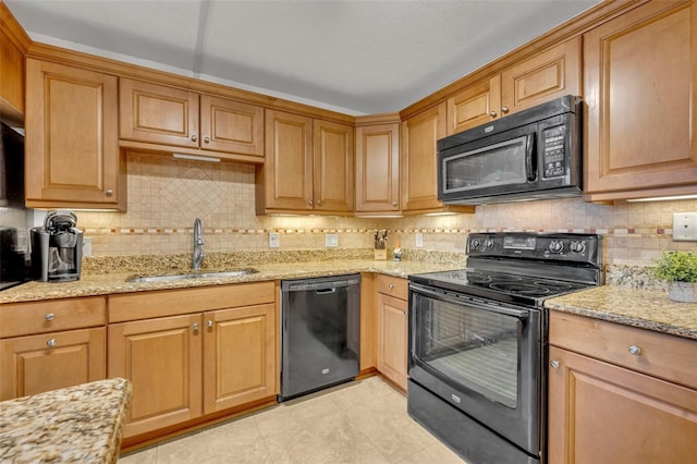 kitchen featuring light tile patterned flooring, sink, black appliances, light stone countertops, and backsplash