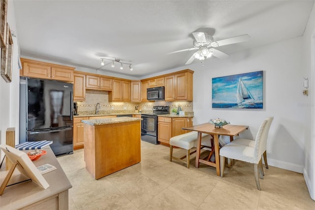 kitchen with light stone counters, tasteful backsplash, black appliances, and a center island