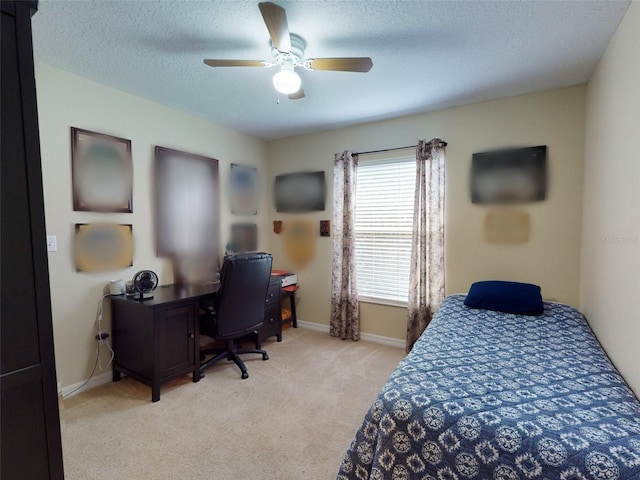 carpeted bedroom with ceiling fan and a textured ceiling