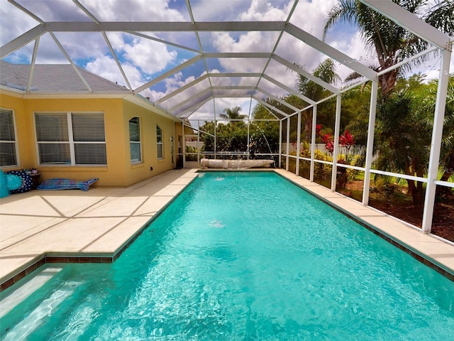 view of pool featuring a lanai, pool water feature, and a patio area