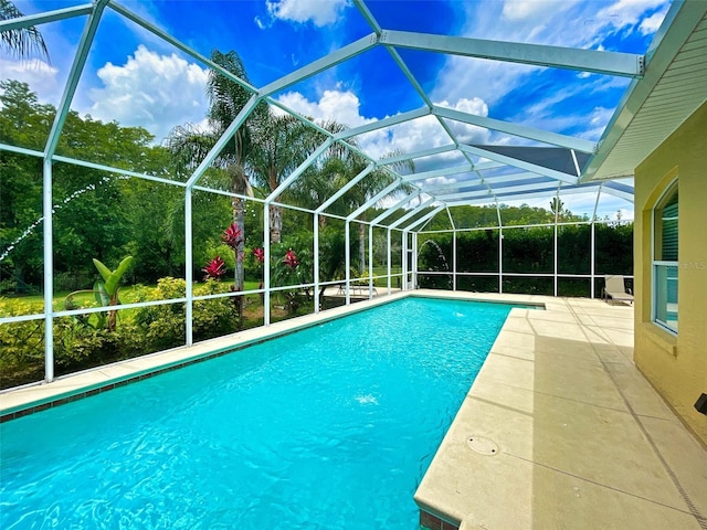 view of swimming pool featuring a patio area and glass enclosure