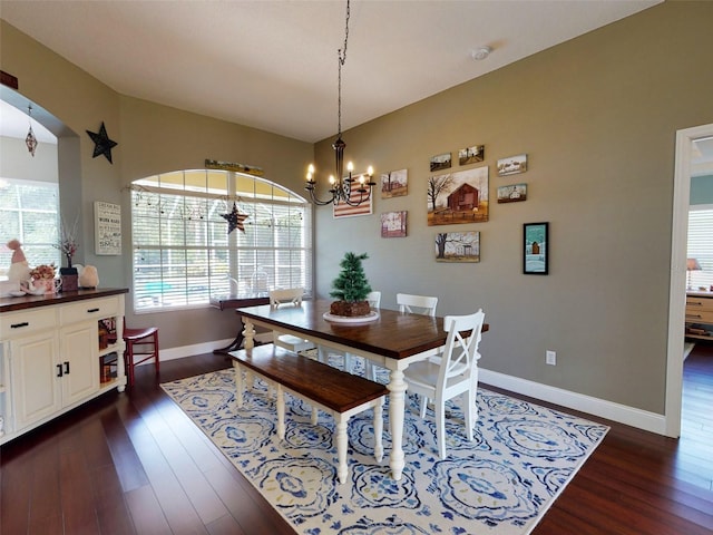 dining space with dark hardwood / wood-style flooring and a chandelier