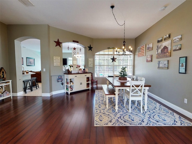 dining space with hardwood / wood-style floors and a chandelier