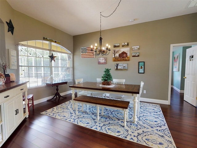 dining space with dark hardwood / wood-style flooring and a chandelier