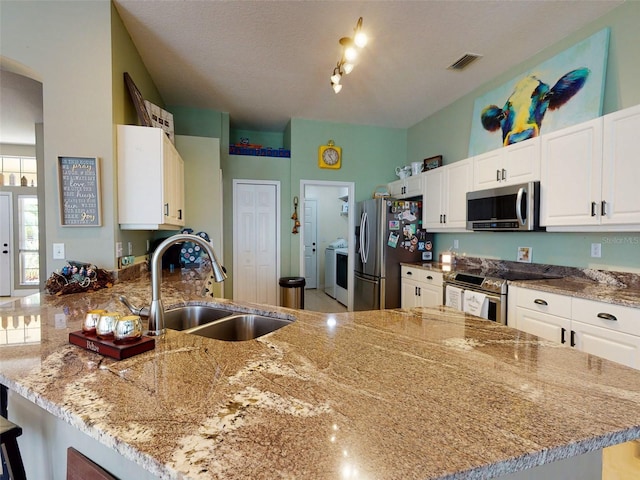 kitchen featuring white cabinetry, stainless steel appliances, kitchen peninsula, and sink