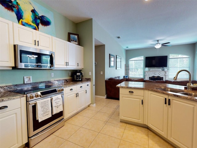 kitchen with white cabinetry, stainless steel appliances, sink, light tile patterned flooring, and ceiling fan