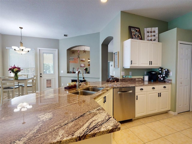 kitchen featuring decorative light fixtures, dark stone counters, a textured ceiling, a chandelier, and sink