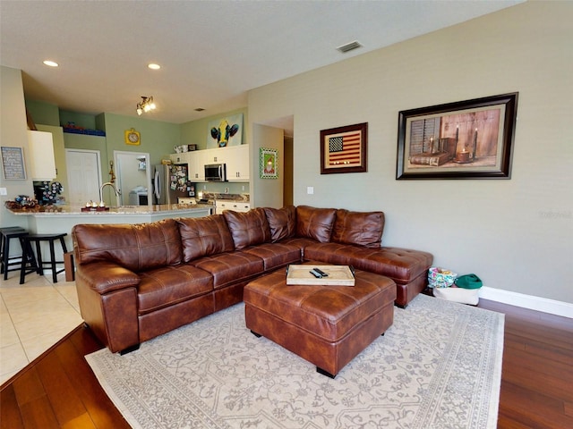 living room featuring light wood-type flooring and sink