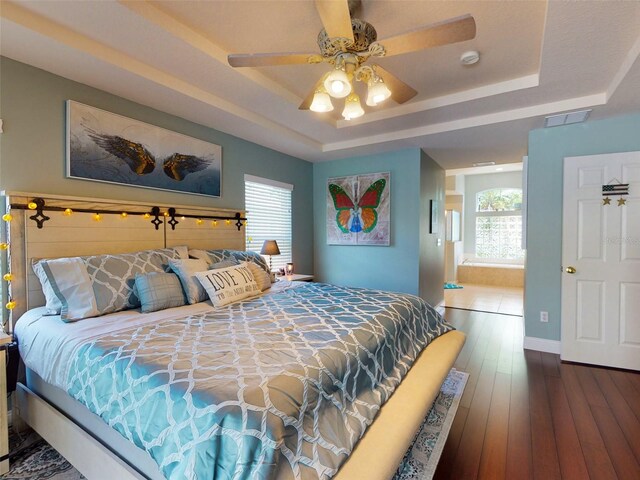 bedroom with a raised ceiling, ceiling fan, and hardwood / wood-style floors