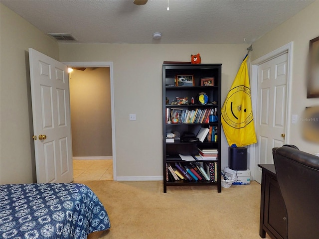 carpeted bedroom featuring a textured ceiling and ceiling fan