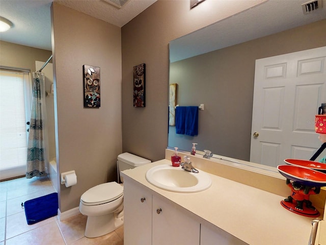 bathroom featuring plenty of natural light, a textured ceiling, toilet, and tile patterned flooring