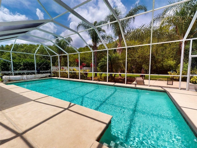 view of swimming pool with a patio area and glass enclosure