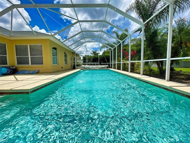 view of swimming pool with a lanai, pool water feature, and a patio area