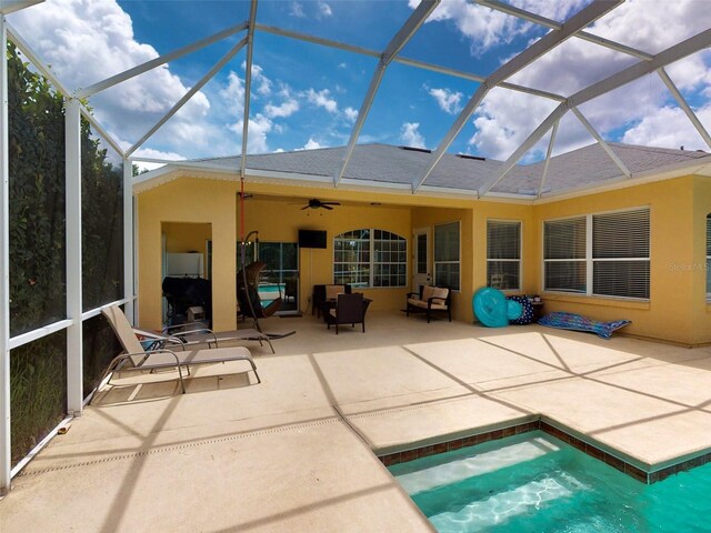 rear view of house with a lanai, ceiling fan, a jacuzzi, and a patio