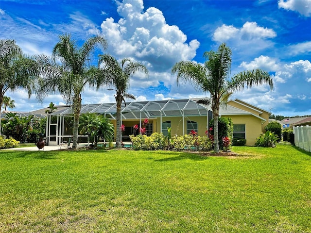 back of property with a lanai and a lawn