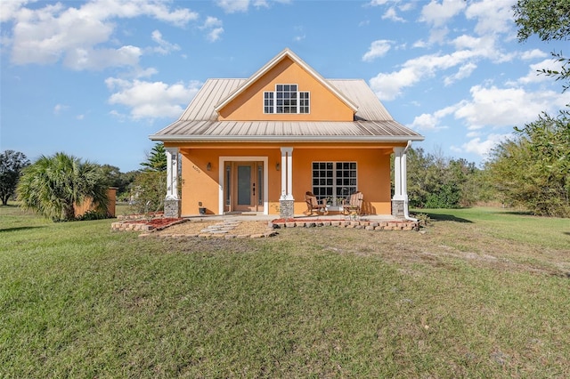 back of property featuring a lawn and covered porch