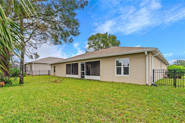 rear view of property featuring a lawn and a sunroom