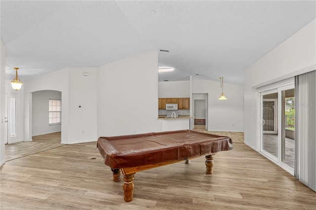 recreation room with a textured ceiling, light hardwood / wood-style flooring, vaulted ceiling, and billiards