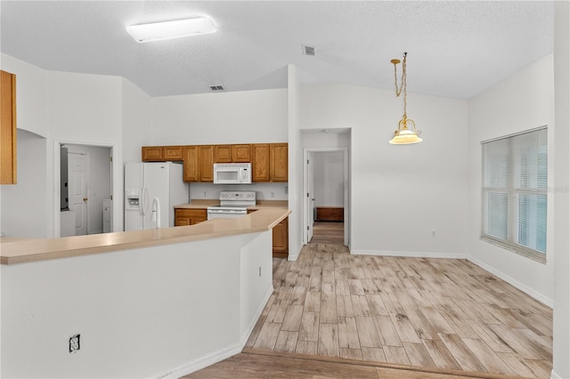 kitchen featuring white appliances, hanging light fixtures, a textured ceiling, light hardwood / wood-style floors, and kitchen peninsula